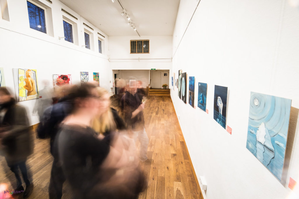 verschwommene fotografierte Menschen betrachten Bilder in einer Kunstaustellung